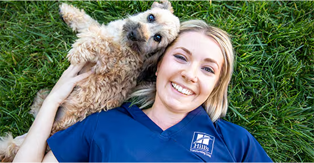 Woman lying with a dog on grass