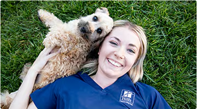 Çimde bir köpekle uzanmış kadın