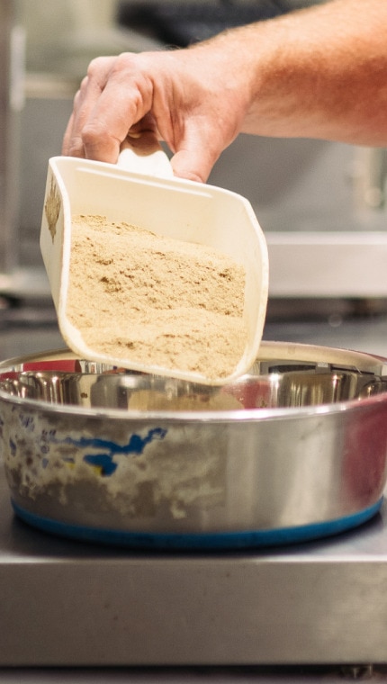 Bir Hill's çalışanı tartı üzerinde malzemeleri ölçüyor