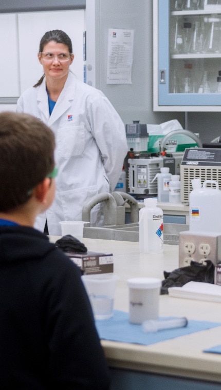 Hill's Pet Nutrition Centre çalışanları çocuklara laboratuvar ekipman ve malzemelerini gösteriyor